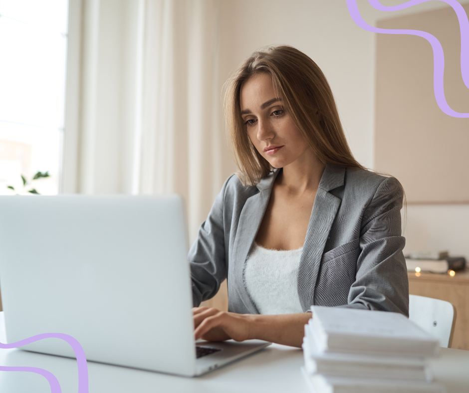 brunette female medical spa front office manager looking at computer and typing